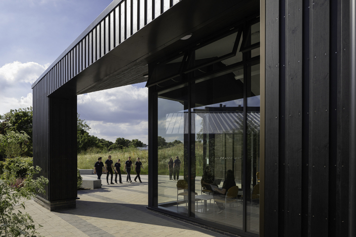 Mock Vets – School of Veterinary Science – University of Nottingham – CPMG Architects people walking towards a black clad building entrance